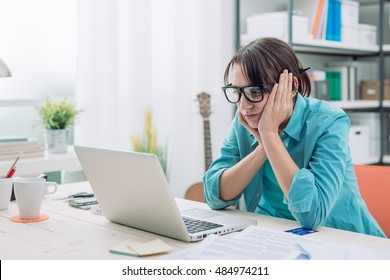 Bored Young Woman In The Office Working With A Laptop And Staring At Computer Screen