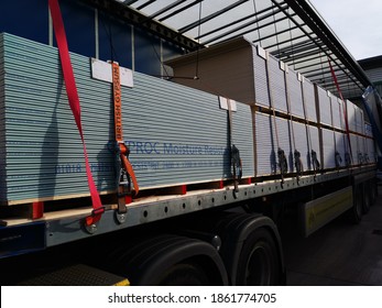 Borehamwood, Hertfordshire UK - November 24 2020: Plasterboard Securely Loaded Onto A Semi Truck Trailer With A Runner Bungie Strap And Ratchet System And Corner Side Protection. 