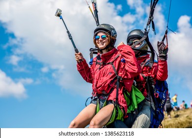 Borgava, Ukraine- June 4, 2018. paragliding in the Carpathians. happy young girl smiles. the first flight paragliding with an instructor. sunny day and blue sky. Ukrainian Carpathian Mountains