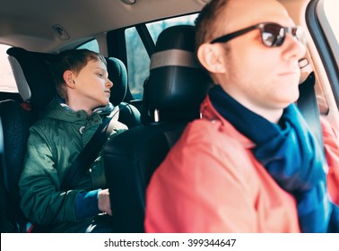 Boring Boy Sitting On The Back Safety Seat In Car