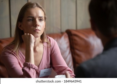 Boring date. Young female sitting at table in coffeehouse having appointment meeting speed dating with male boyfriend feeling dull dissatisfied losing her time, listening to partner without interest