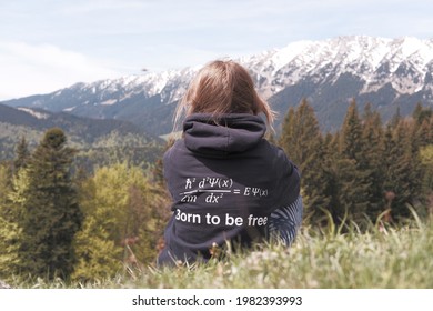 Born to be free, Physics student wears a hoodie with a funny formula joke while she admires snowy mountaons and the forest during a hike