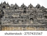 Borobudur, Central Java, Indonesia - July 12, 2024: Majestic stone stupas of the world’s largest Buddhist temple at sunrise. Ancient UNESCO heritage site showcasing intricate reliefs and statues.