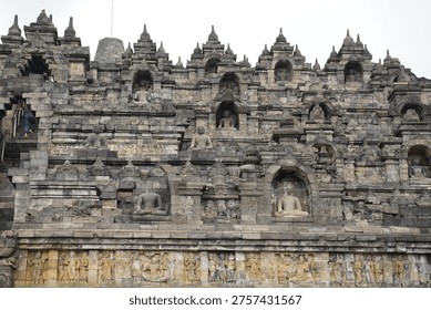 Borobudur, Central Java, Indonesia - July 12, 2024: Majestic stone stupas of the world’s largest Buddhist temple at sunrise. Ancient UNESCO heritage site showcasing intricate reliefs and statues.