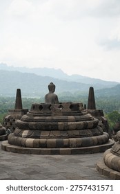 Borobudur, Central Java, Indonesia - July 12, 2024: Majestic stone stupas of the world’s largest Buddhist temple at sunrise. Ancient UNESCO heritage site showcasing intricate reliefs and statues.