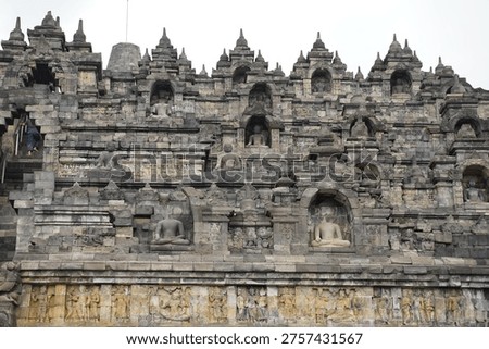 Borobudur, Central Java, Indonesia - July 12, 2024: Majestic stone stupas of the world’s largest Buddhist temple at sunrise. Ancient UNESCO heritage site showcasing intricate reliefs and statues.