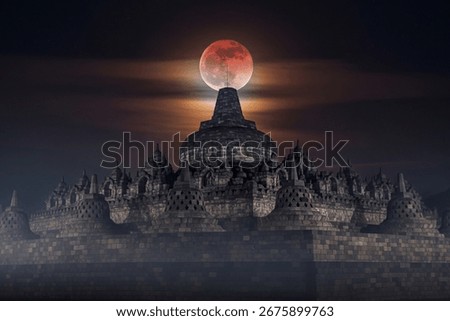 Borobudur Temple in Central Java, Indonesia, at night with a dramatic blood moon glowing above the ancient Buddhist monument. Mystical and spiritual atmosphere, perfect for travel, culture, and celest