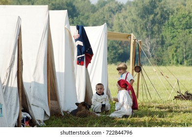 BORODINO, RUSSIA - SEPTEMBER 2, 2017: Unidentified children playing with dog just before historic reconstruction of battle in 1812 near Borodino village, Russia