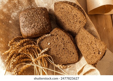 Borodinsky rye bread with thyme in a basket with ears of barley on a canvas cloth,. High quality photo