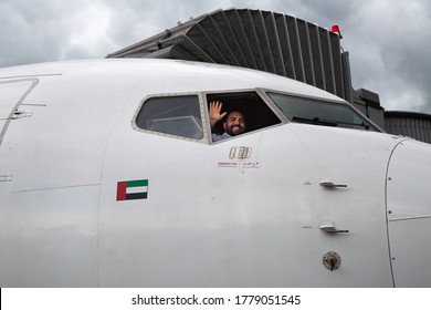 Boryspil, Ukraine - JULY 08, 2020: FlyDubai pilot smiling and waving hand from the cockpit. Flight with FlyDubai airline. Dubai travel. Modern airport. UAE airline.