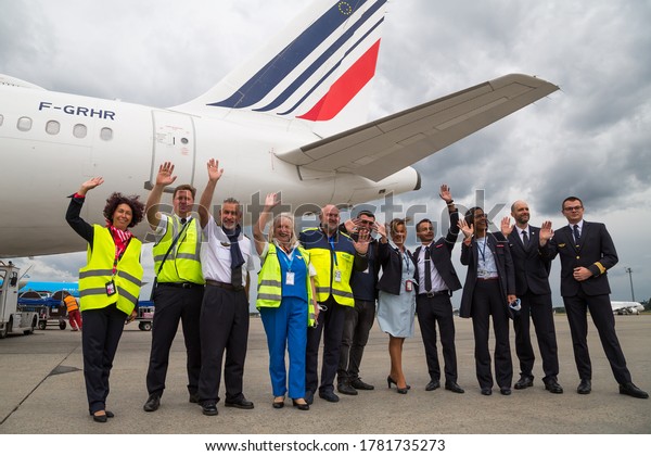 Boryspil, Ukraine - JULY 14, 2020: Air\
France airline staff. Smiling airline pilots, flight attendants,\
workers. Airline logo. Airport overview. Airbus\
aircraft.