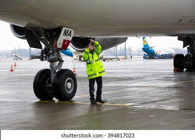 Boryspil, Ukraine - MARCH, 2016: Airport worker near aircraft Airbus A340. Airport ground handling worker. Airport handling service loadmaster at work on March 20, 2016 in Boryspil