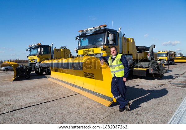 BORYSPIL, UKRAINE - NOVEMBER 05, 2019: Airport snow\
removal vehicles. Snow removal trucks. Truck driver. Airport\
worker. Runway cleaning.\
