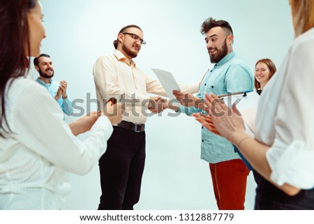 Boss approving and congratulating young successful employee of the company for his successes and good work. National Employee Appreciation Day, businesswoman, businessman, business, success, admire