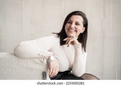The boss is a business woman smiling, showing her teeth, in beige office clothes. Good mood in the office during the day. - Shutterstock ID 2255005281