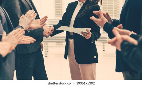 boss congratulating the best employee at a work meeting