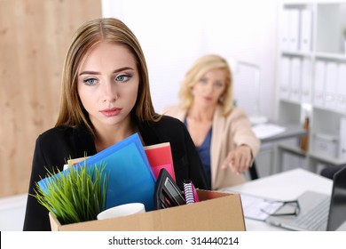 Boss dismissing an employee. Dejected fired office worker carrying a box full of belongings. Getting fired concept.