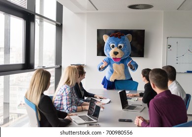 Boss Dresed As Teddy Bear Having Fun With Bussines People In Modern Corporate Office