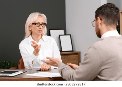 Boss and employee discussing work issues at wooden table in office - Shutterstock ID 2303292817