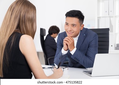 Boss Is Smiling To His New Secretary Thinking About Countless Hours They Will Spend Together In Their White Office With Bookcase. Concept Of New Employee