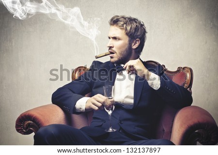 boss smokes cigar with a glass of champagne