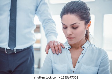 Boss touching secretary. Man in official clothes putting his hand on woman shoulder without permission