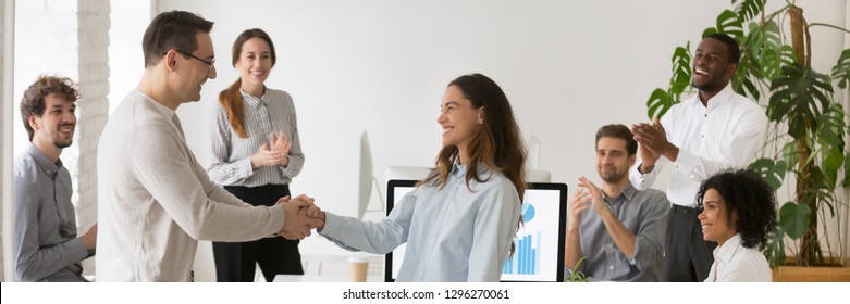 Boss welcoming new employee hired intern female, mixed race woman feel happy promoted receive appreciation for good work result from company head colleagues applauding banner for website header design