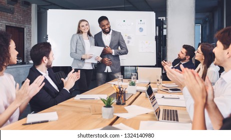 Boss Welcoming New Employee And Representing To Colleagues At Meeting