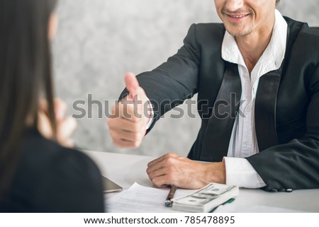 Boss/Business man employer admires young Asian business woman/staff/employee by thumb up and hands clap with smiling face for her success and good/best in work and recognition/appreciate.