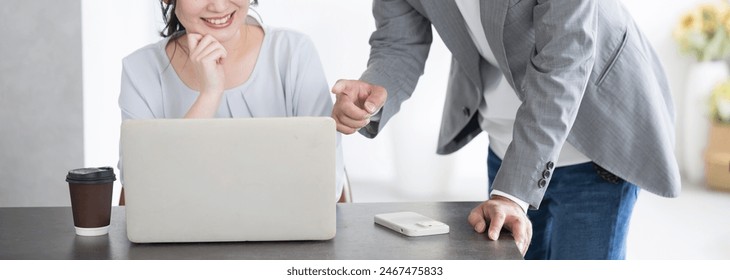 Bosses instructing subordinates in front of computers with smiles on their faces, men and women in office casual wear. Images of new employee training and on-the-job training. Faceless.