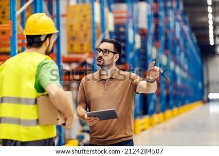 A bossy supervisor giving command to storage worker for shipment.