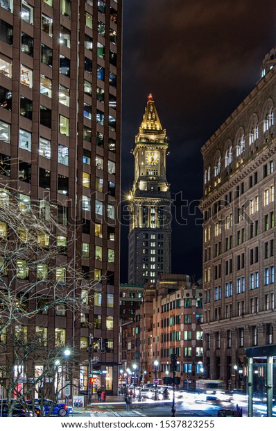 Boston, MA—Feb 13, 2019; Cars pass by in time\
exposure with The Custom House Tower skyscraper in McKinley Square,\
in the Financial District neighborhood in the background at night\
in winter.