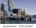 Boston bridge and Boston Tea Party museum in front of city skyline on Boston Harbor.