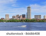 Boston city skyline with Prudential Tower and urban skyscrapers over Charles River with boat.