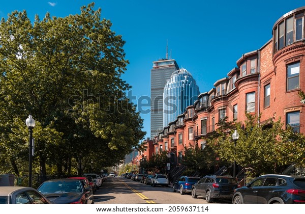 Boston city street\
landscape with red brick buildings, cars, and skyscrapers on West\
Newton Street