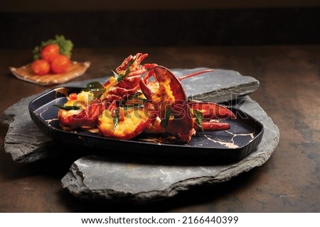 Boston Lobster tossed with Salted Egg Yolk served in a dish side view on wooden background
