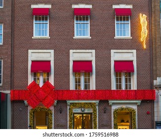 Boston, MA - 12/8/18: A Red Bow With Festive Christmas Lights Welcomes Holiday Shoppers To A Newbury Street Boutique. 