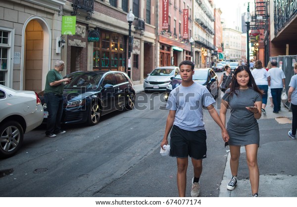 BOSTON,\
MA, July 2, 2017: A couple goes on a date on a beautiful evening in\
the popular North End neighborhood. North End is known for\
historical architecture and a vibrant\
nightlife.