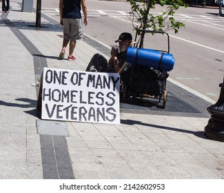 Boston, MA. USA - May, 2014; Homeless veteran sitting on the roadside asking for help. 