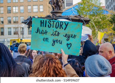 Boston, MA, USA â?? November 11, 2016. Protesters at anti-Trump Love Rally in Boston Common following the US presidential election of Donald Trump hold a sign stating "History has its eyes on you".