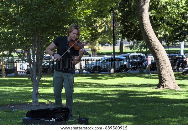 Boston, Massachusetts, USA - September 12, 2016: A male\
violinist play classical music in Boston Public Gardens in Boston,\
