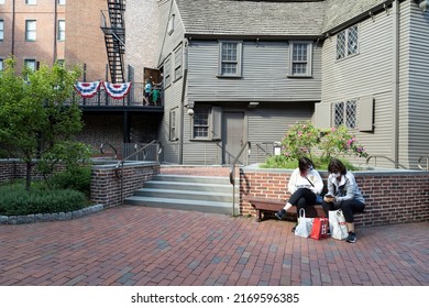 Boston, Massachusetts, USA-June 4, 2022 Two tourists sitting outside the house of Paul Revere 