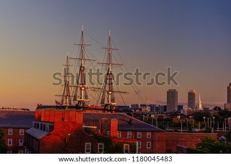 Boston skyline with USS Constitution. masts of a historic ship on the background of the setting sun
