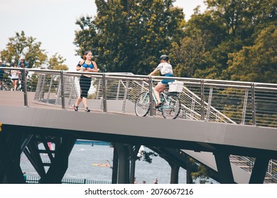 BOSTON, USA - JULY 14, 2021 : People ride a bike and running Crossing overpass to Charles River esplanade in the summer at Boston, USA.