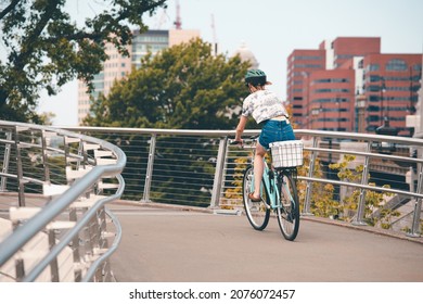 BOSTON, USA - JULY 14, 2021 : People ride a bike Crossing overpass to Charles River esplanade in the summer at Boston, USA.