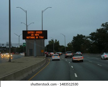 Boston, USA-September 2017: Night Shot Of Cars On A Winding Road With A Digital Speed Limit Sign In Boston.