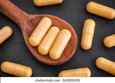 Boswellia capsules in a wooden spoon. Close up.
