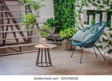 Botanic style in the interior / armchair with a table and a magazine