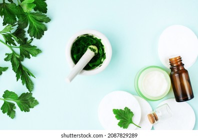 Botanical cosmetic product top view fresh green parsley plant leaves mashed for facial mask on light blue background, herbal skin care and organic beauty treatment homemade recipe