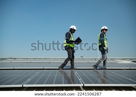 Both of Engineer in charge of solar panel installation The installation of solar energy conversion into electricity for a warehouse is currently being investigated.